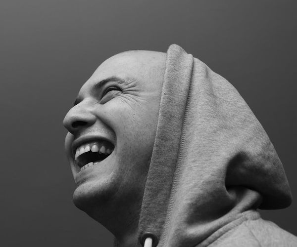 Smiling person standing in nature feeling refreshed and full of energy.