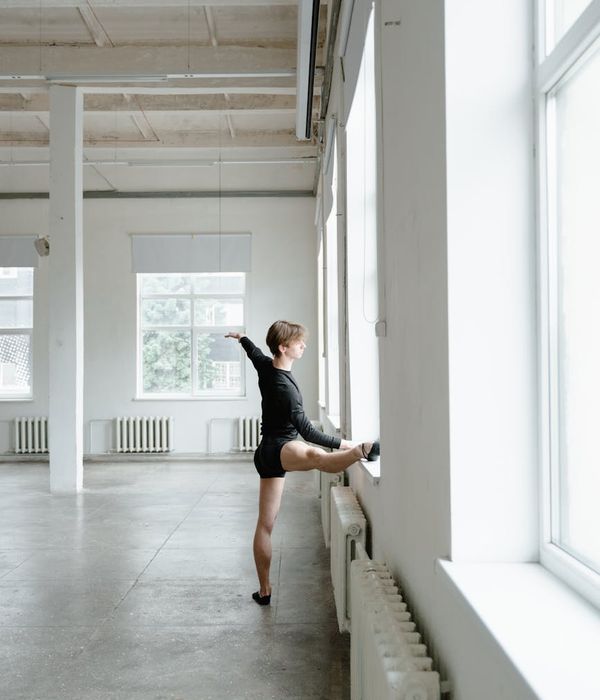 Young woman practicing energy movements in a bright modern studio.